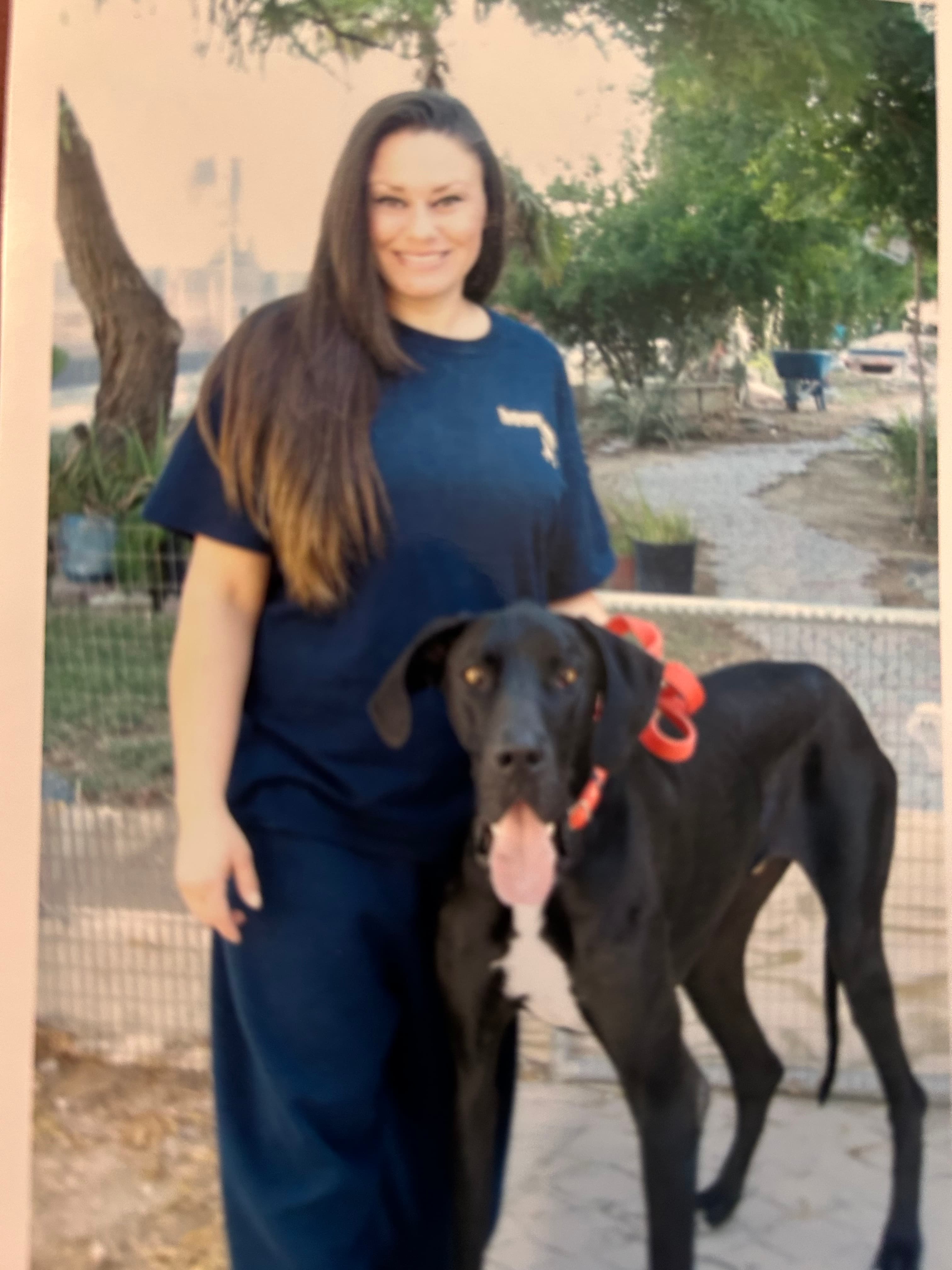 Stephanie with a large black dog during an outdoor training session